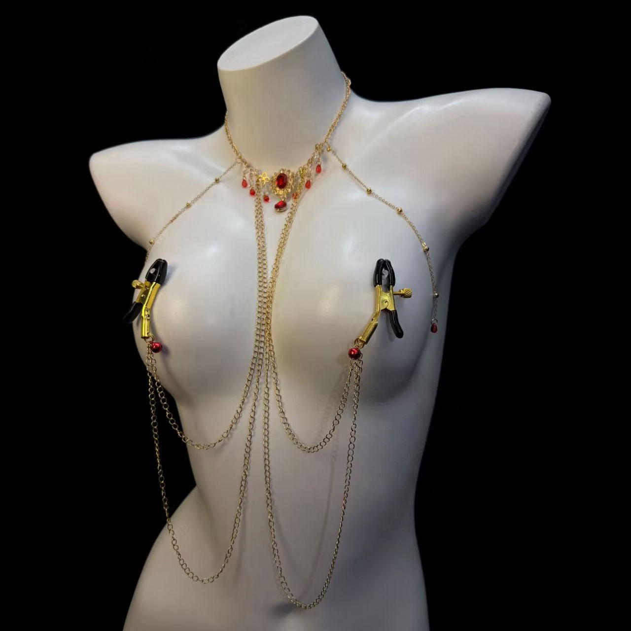 Connected gothic body jewelry featuring gold filigger bell charm on hip and traditional alligator breast clamps.