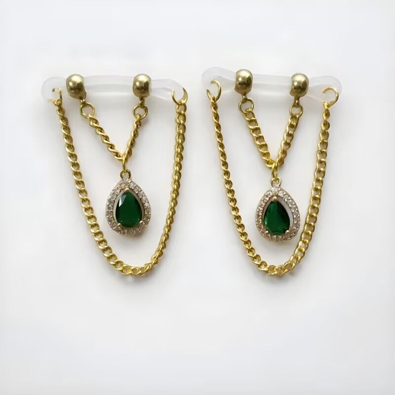 Fake nipple clamps featuring emerald green teardrop gems mounted on clear silicone adjustable straps.