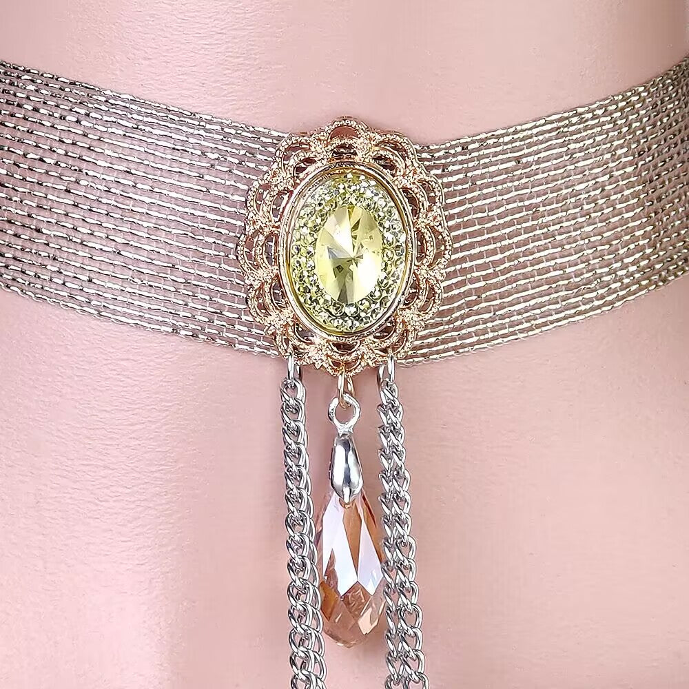 Detailed view of the filigree-framed oval yellow crystal focal stone and teardrop glass charm on a choker collar.