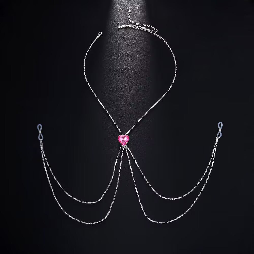 Fuchsia pink heart crystal non-pierced nipple clamp jewelry harness with silver chain accents on dark background.