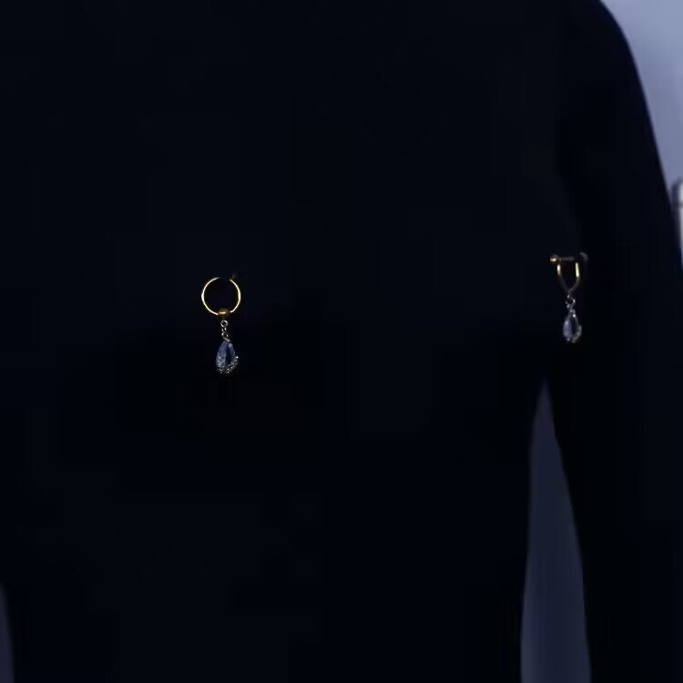 Display of gold tear drop dangle pierced nipple rings worn on body showing elegant fit