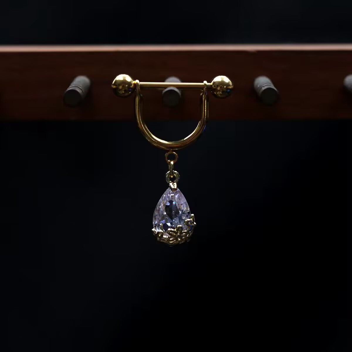 Pierced gold barbell shield nipple ring with hanging teardrop cubic zirconia crystal pendant