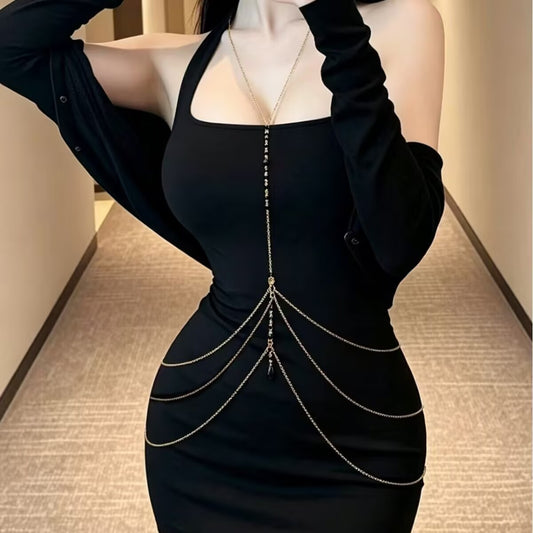 Gold Y-lariat body chain with black crystal beads worn over a black fitted dress.