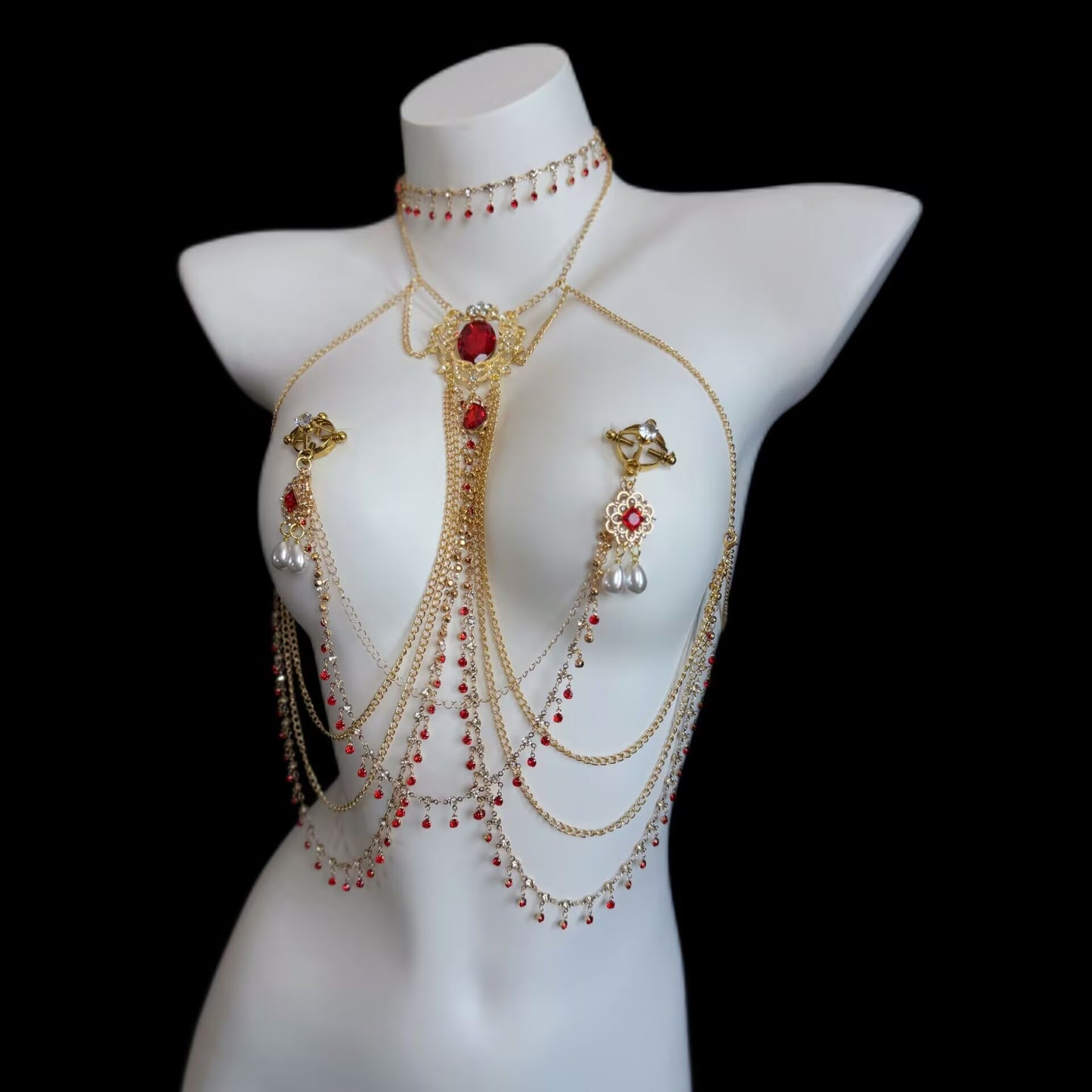 Complete gold body chain harness paired with non-pierced ring-clamp breast jewelry, decorated with ruby centerstones, crystal accents, and double pearl drops.