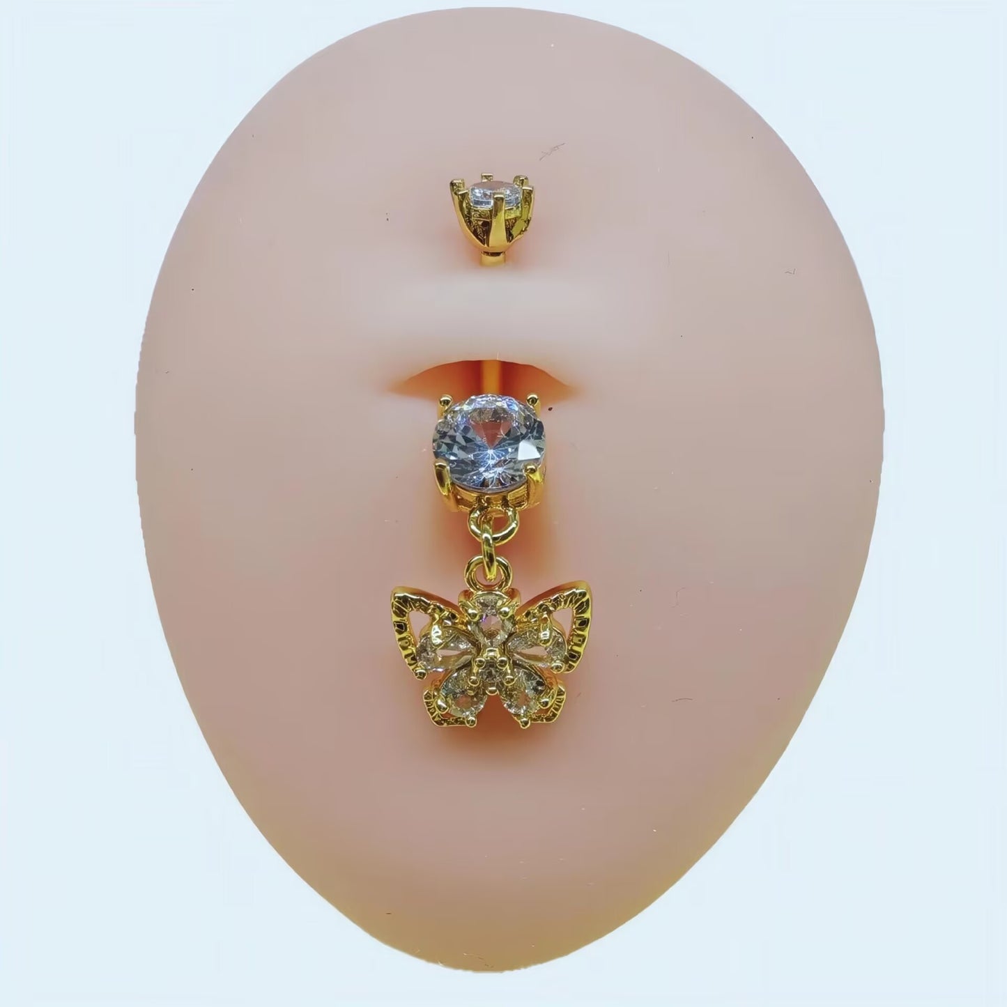 14K gold plated butterfly dangling belly button ring with double clear cubic zirconia crystals shown on a piercing model.