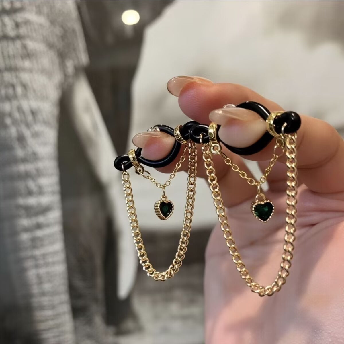 Side view of multiple non-pierced gold drape chains and heart charms showing the layered jewelry look.