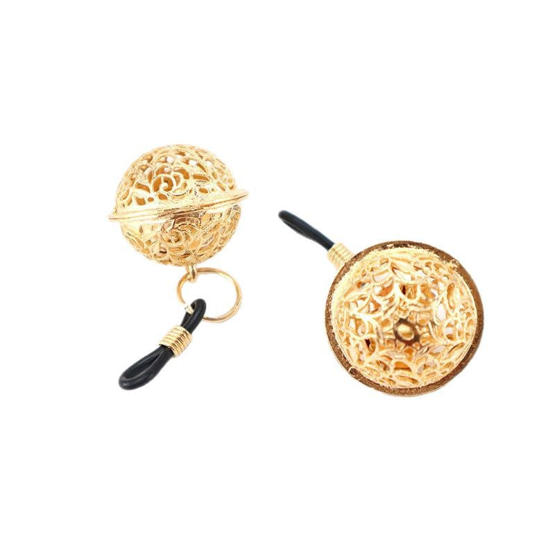Close-up of elegant gold-toned filigree sphere charms on adjustable black sensory loops.
