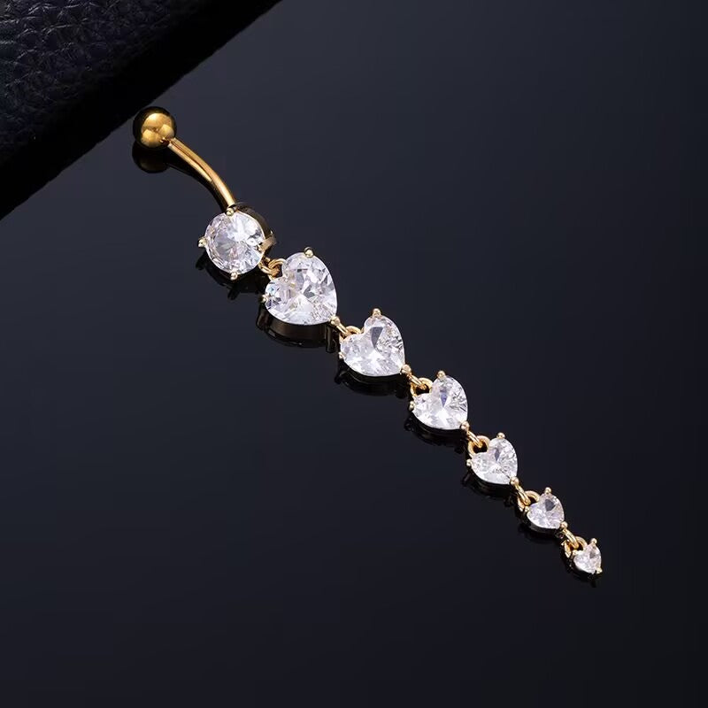 Gold dangle belly button ring with cascading heart-cut cubic zirconia stones for navel piercing jewelry.