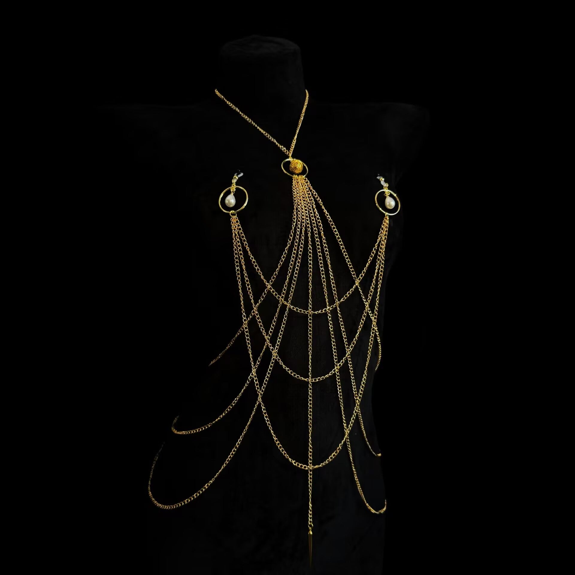 Gold layered body chain harness with non-pierced pearl ring nipple accents shown on black mannequin
