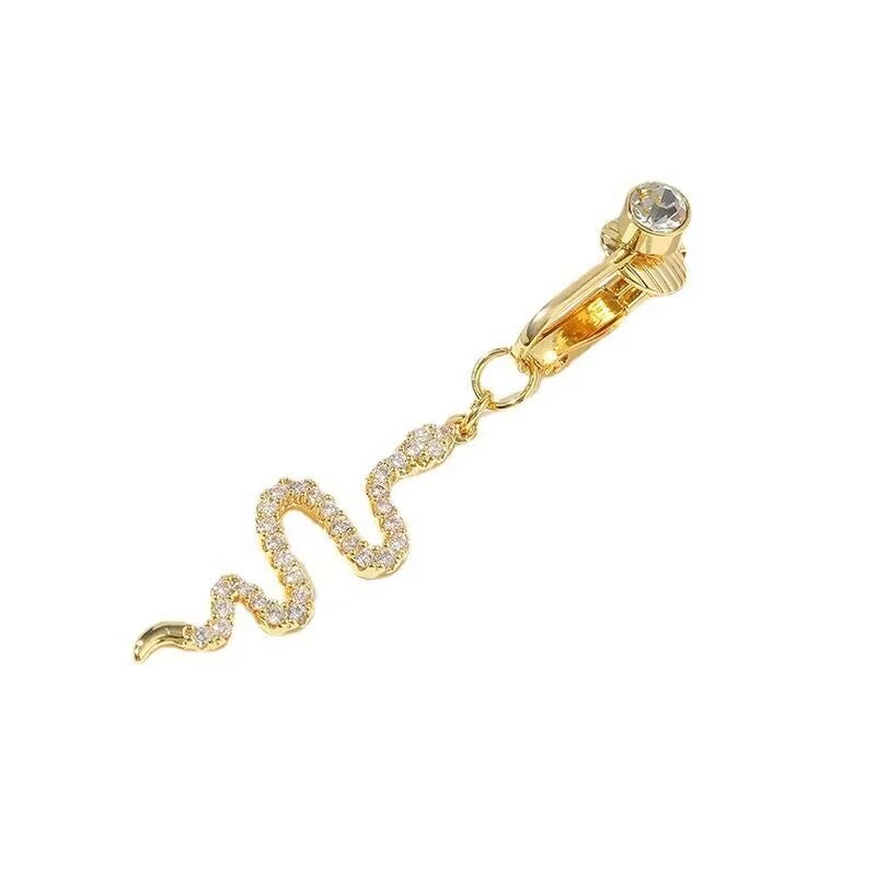 Close-up detail of gold clip-on snake fake navel ring with crystal top accent