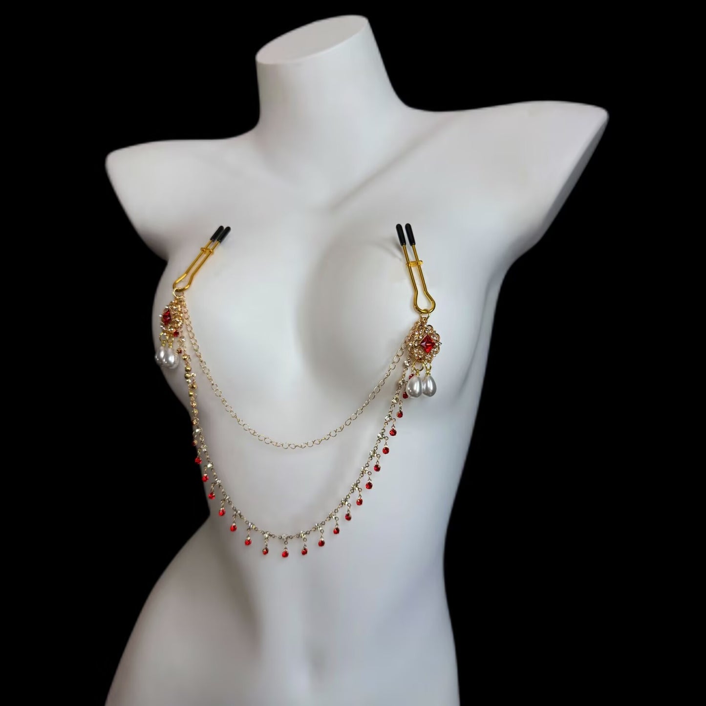 Front view of a gold U-shaped clamp nipple chain featuring comfortable black rubber tips, red rhinestone drops, and connected gold chains.