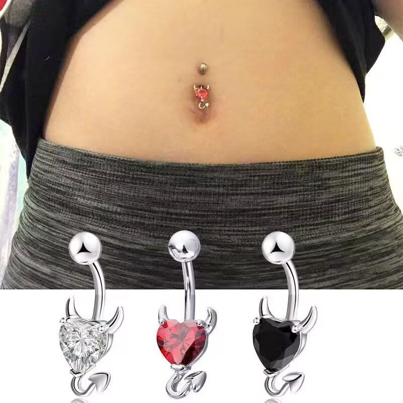 Real life model wearing a red devil heart navel ring piercing paired with low-rise pants showing Y2K goth aesthetic.