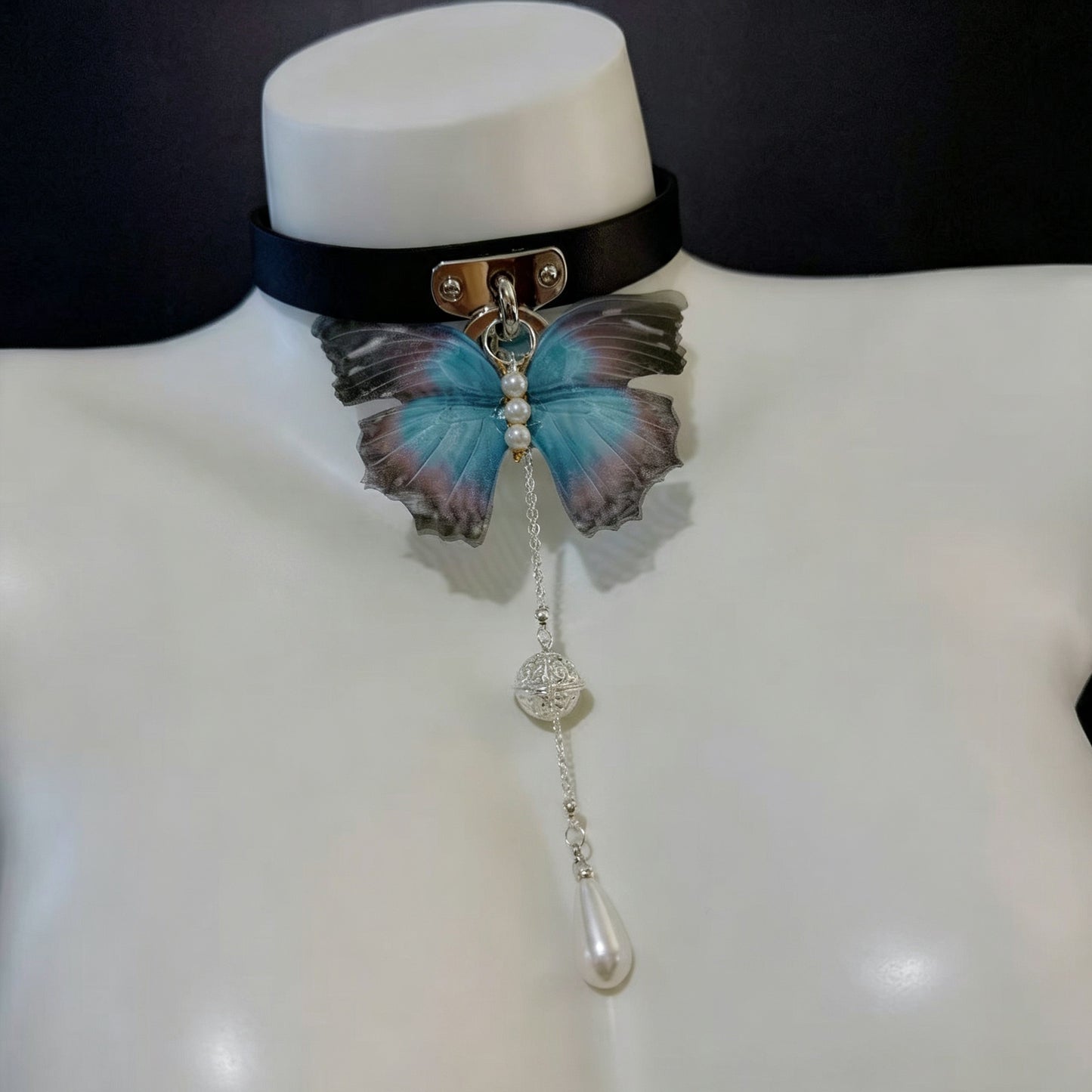 Black leather gothic choker collar with translucent blue butterfly pendant, filigree bead, and pearl drop.