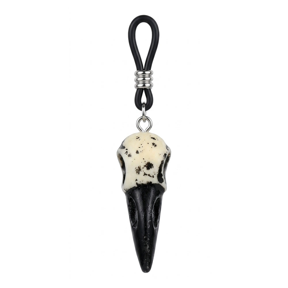 Close-up of a single weathered white and black crow skull pendant attached to an adjustable black nipple loop.