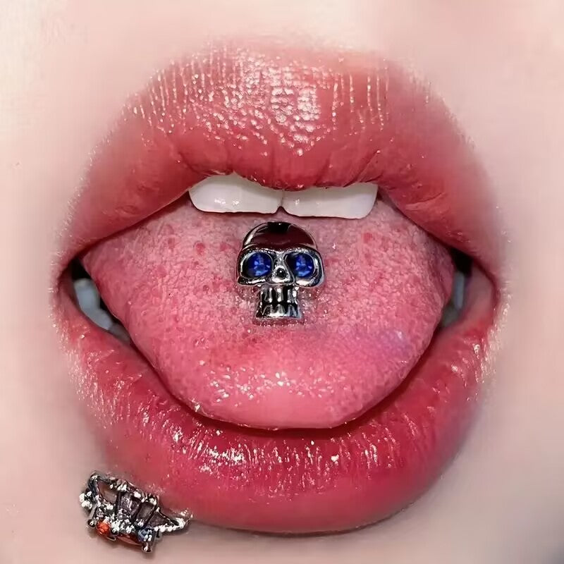 Model showing a gothic crystal skull tongue barbell with blue crystal eyes inside mouth.