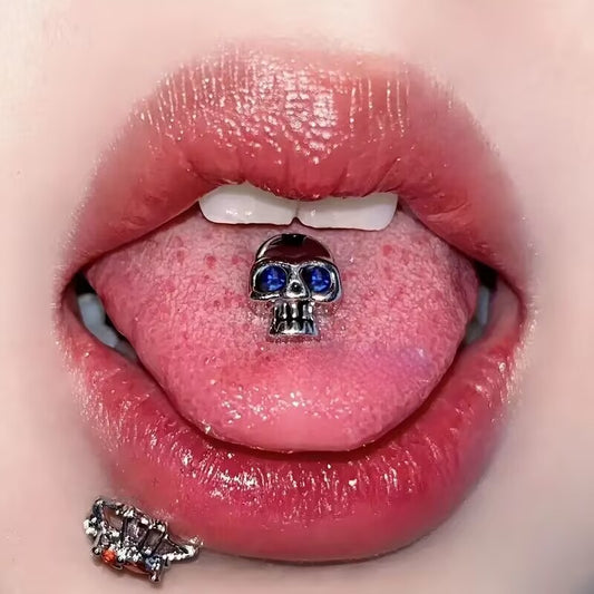 Model showing a gothic crystal skull tongue barbell with blue crystal eyes inside mouth.