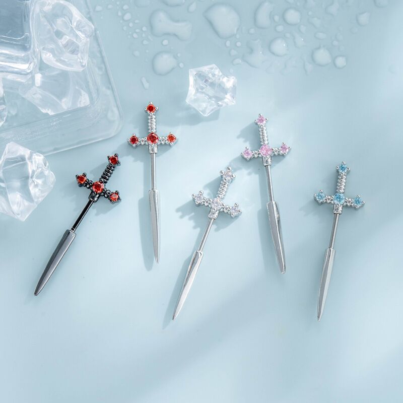 A display of gothic crystal dagger sword stud earrings in red, pink, blue, clear, and black color variations.