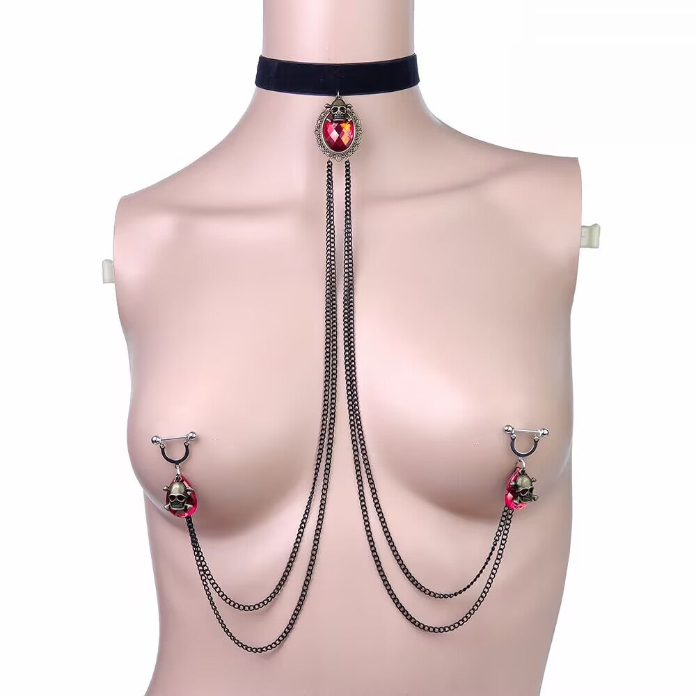 Gothic red crystal teardrop choker connected with chains to red skull nipple rings on mannequin.