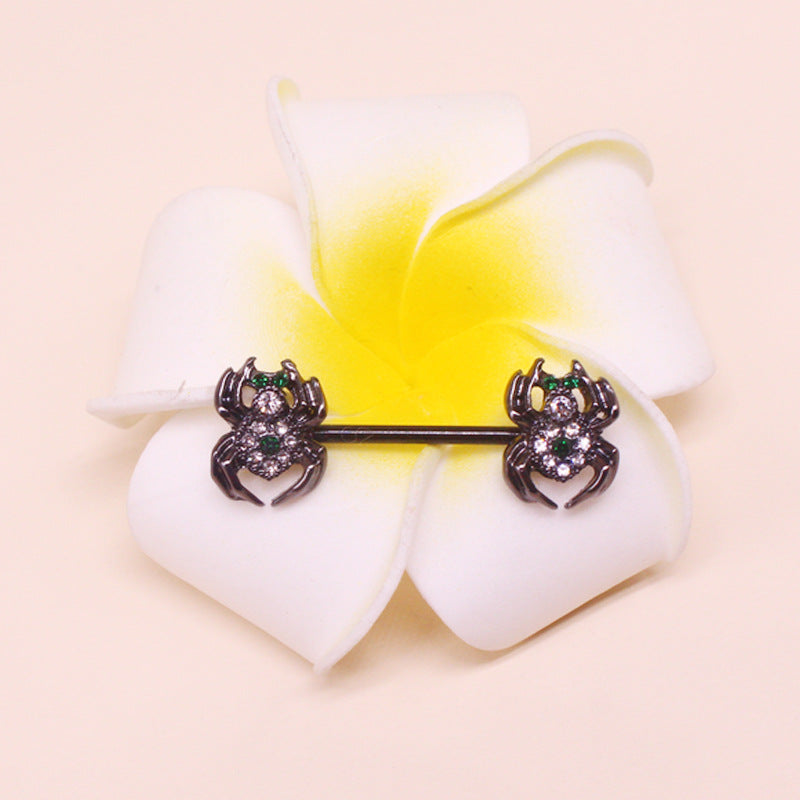 A decorative spider nipple barbell placed on a tropical white flower, showcasing the intricate green and white crystal details in a lifestyle setting.