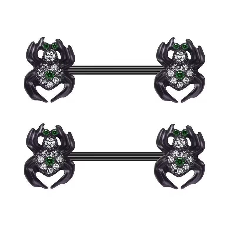 Front view of two black spider-shaped nipple barbells with emerald green and clear crystal details on a white background.