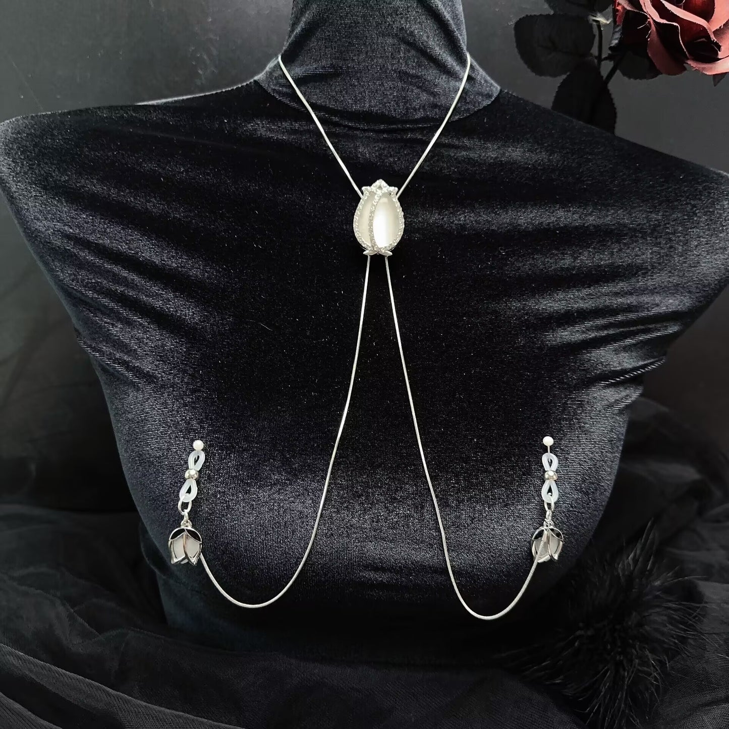 Gothic-style tulip nipple clamp harness chain with delicate silver neck chain on black velvet background.