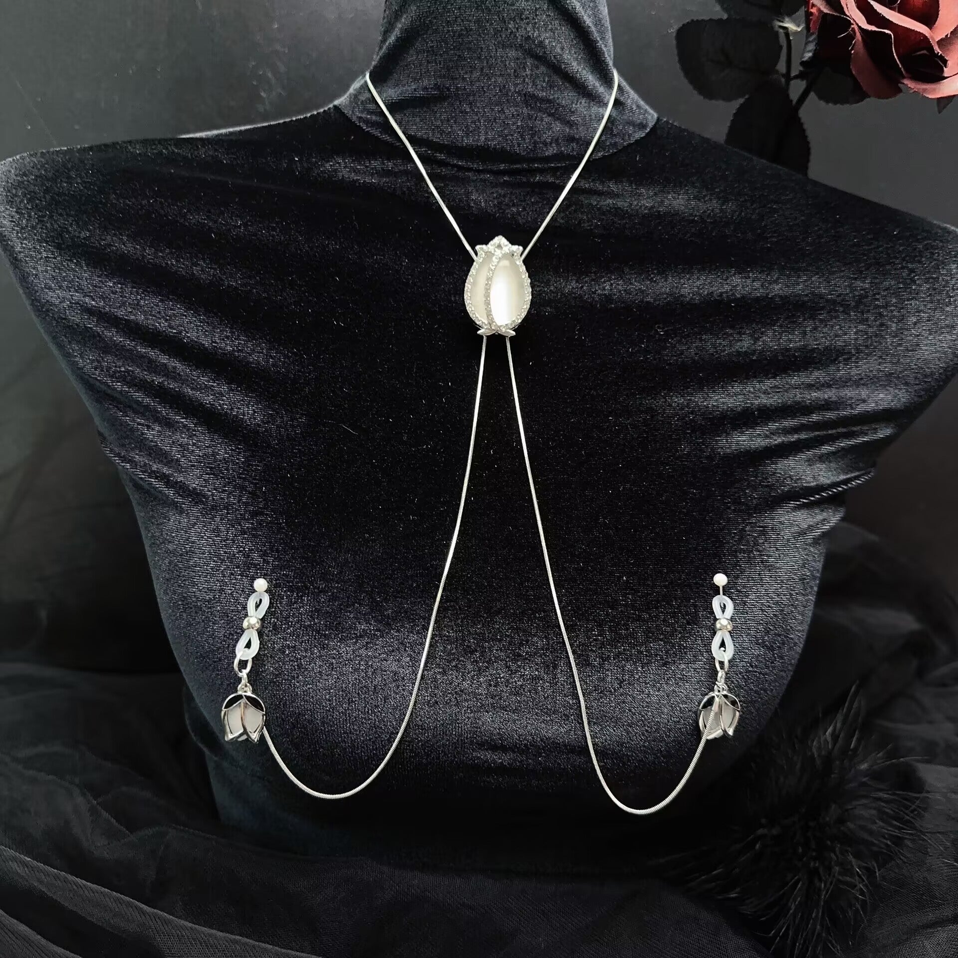 Gothic-style tulip nipple clamp harness chain with delicate silver neck chain on black velvet background.