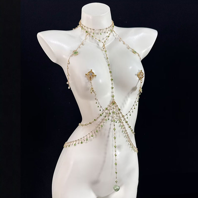 Close-up view of a silver body chain harness featuring peridot green crystals and delicate chains, attached with non-pierced, adjustable nipple loop jewelry on a female mannequin.