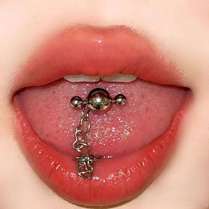 Heart chain tongue ring with cross barbell design front view worn on tongue