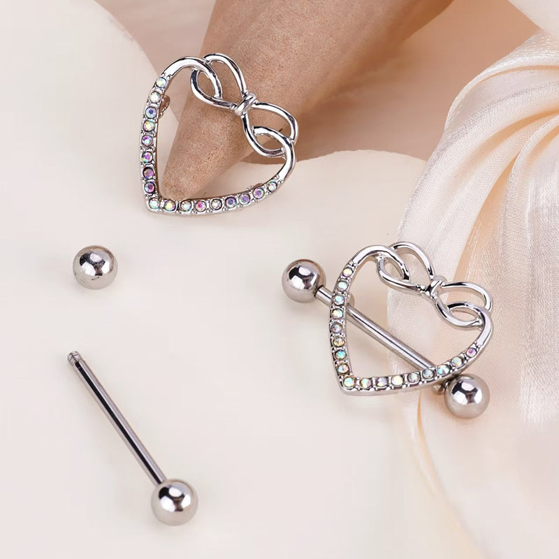 Close-up detail of the heart nipple shield jewelry showing the removable straight barbell, screw-on ball ends, and the crystal-encrusted heart frame.