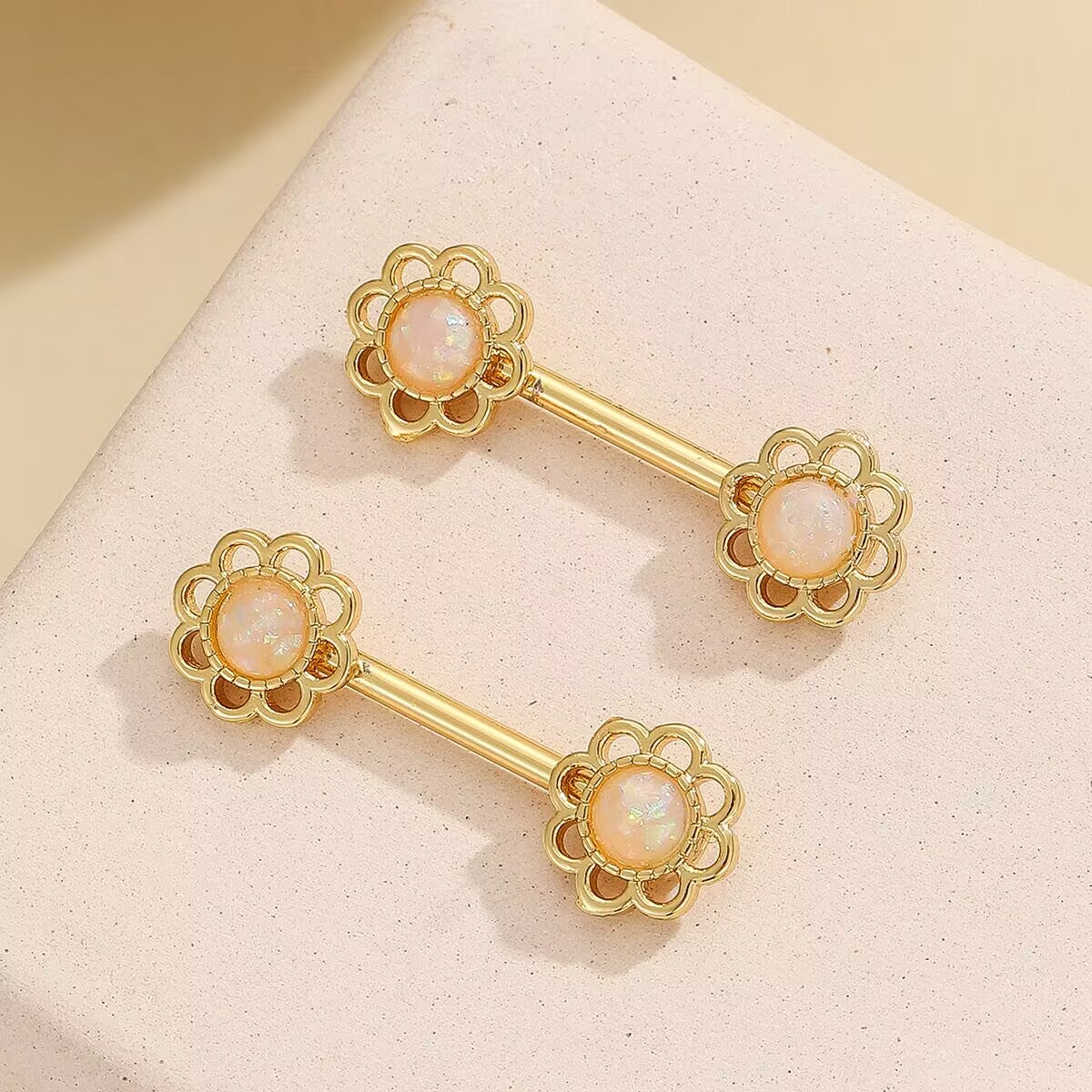 Elegant non-pierced nipple jewelry featuring white iridescent flower charms.
