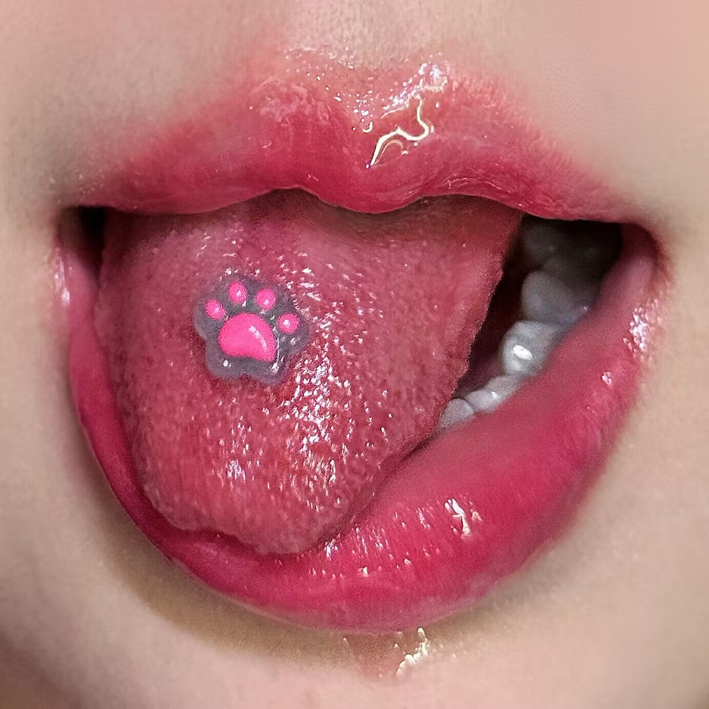 Close-up shot of a girl wearing a cute pink translucent resin cat paw tongue ring, kawaii Y2K body piercing jewelry