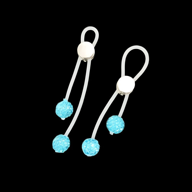 Pair of lake-blue non-piercing nipple clips with translucent straps and sparkling bead drops against black.