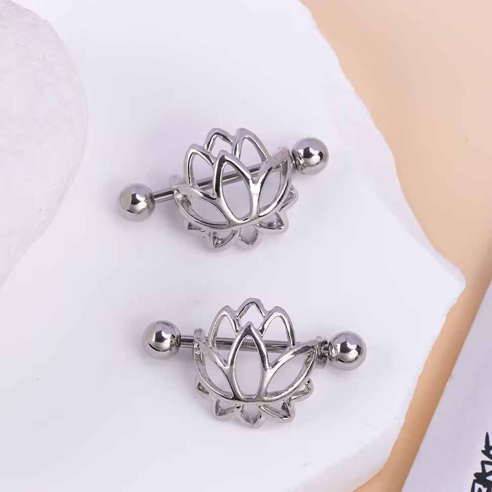 A pair of polished lotus flower nipple shields with horizontal barbells, displayed on a clean white surface.