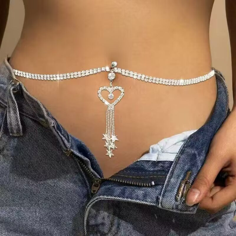 Model wearing a sparkling rhinestone love heart belly button ring connected to a double row waist chain on low rise jeans.