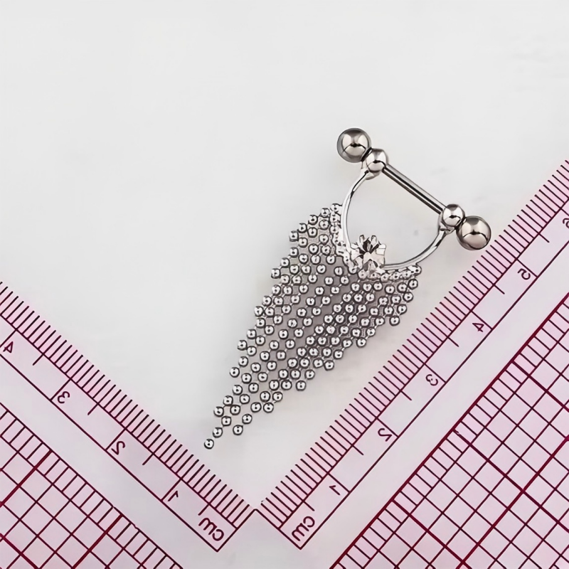 Flat lay of the beaded tassel nipple piercing jewelry placed next to a measuring ruler to show size and dimensions.