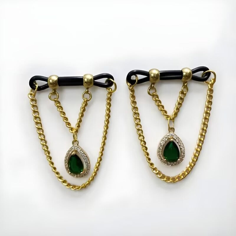 Non-pierced body chain nipple jewelry with dark green teardrop crystals and gold link chains on black tension bands.