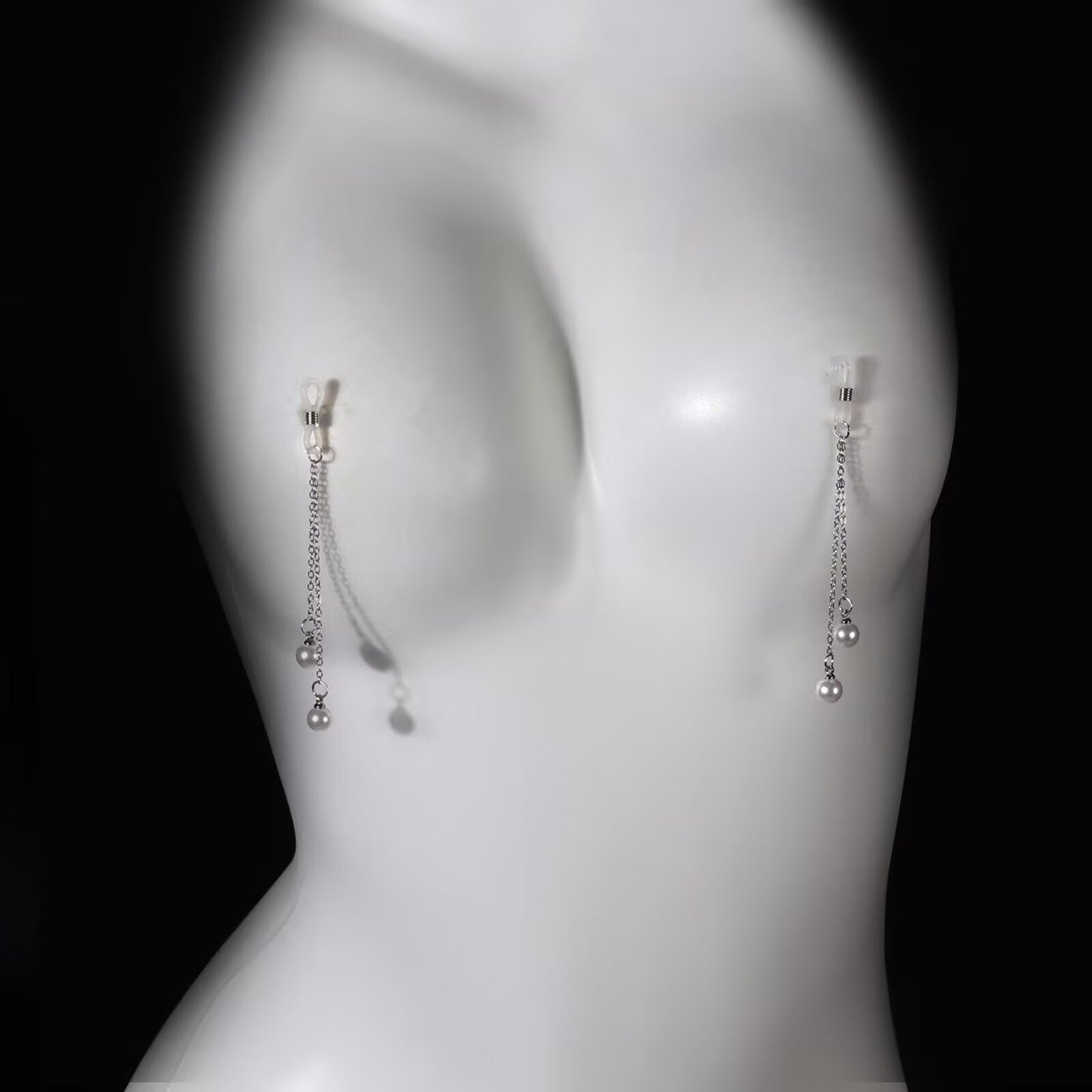 Pair of non pierced pearl nipple clamps with adjustable silicone loops and hanging pearl chains displayed on mannequin.