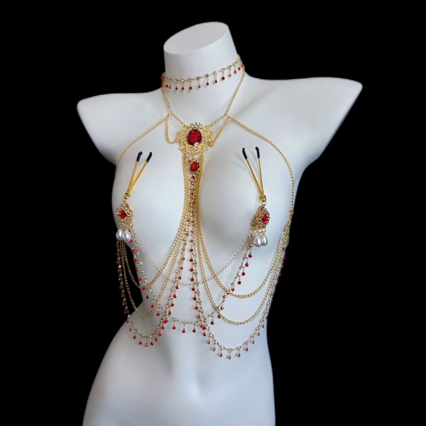 Angled view of non-pierced U-clamp breast chain integrated with a multi-strand gold choker body jewelry set, featuring red gems and cascading chain tassels.