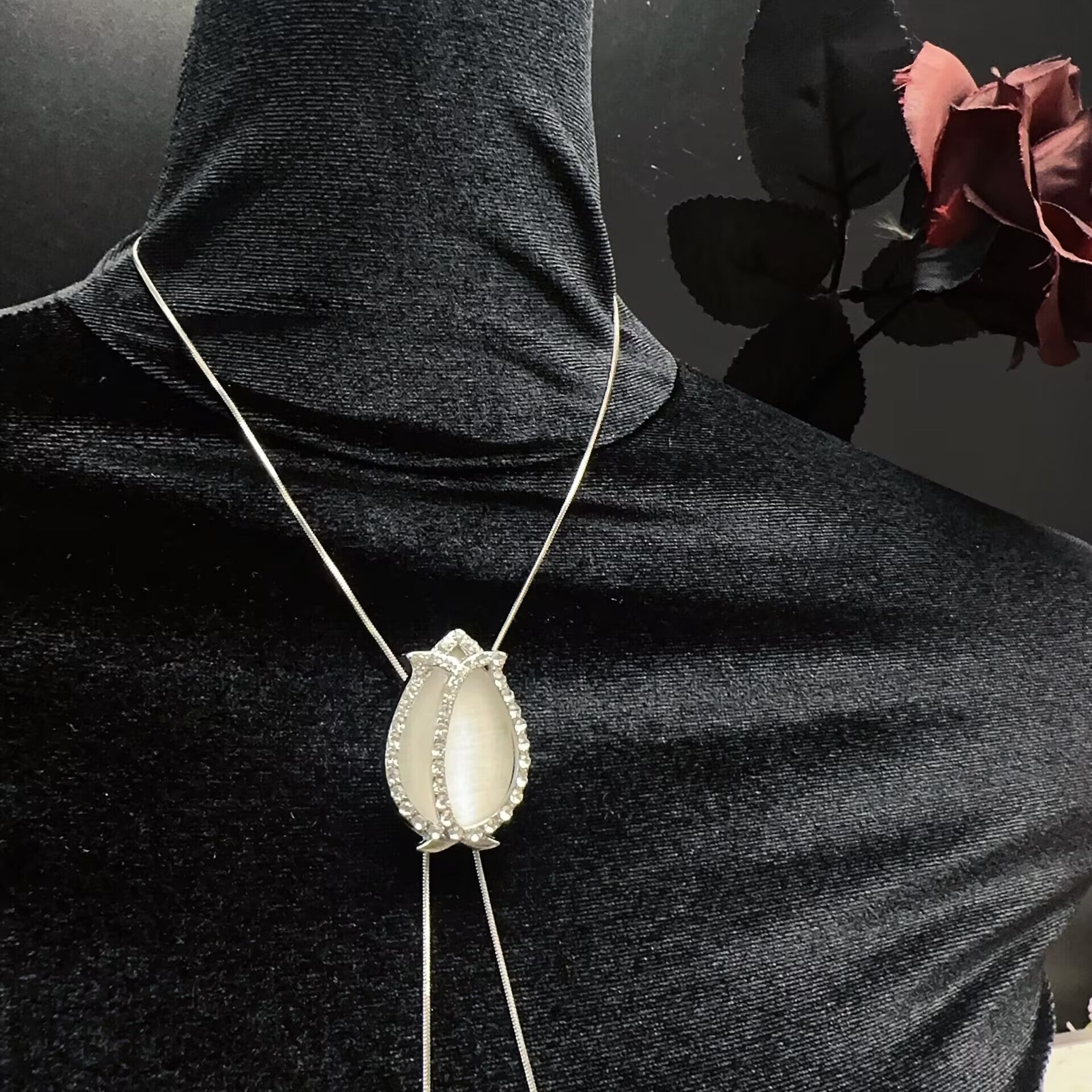 Close-up of opal tulip center slider pendant with rhinestone accents on a body chain necklace.