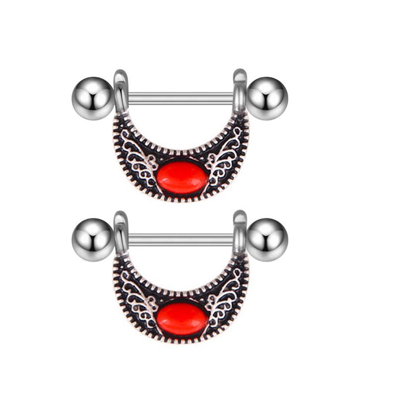 A matching pair of antique silver nipple piercing shields featuring intricate bohemian engravings and red accents.