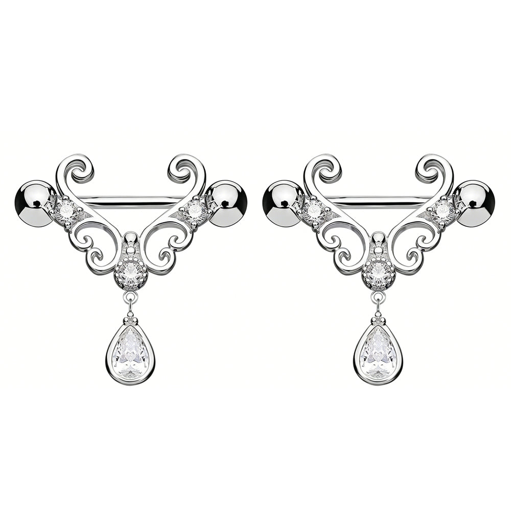 A matching pair of decorative nipple shields featuring intricate scrollwork and elegant pear-shaped crystal pendants.