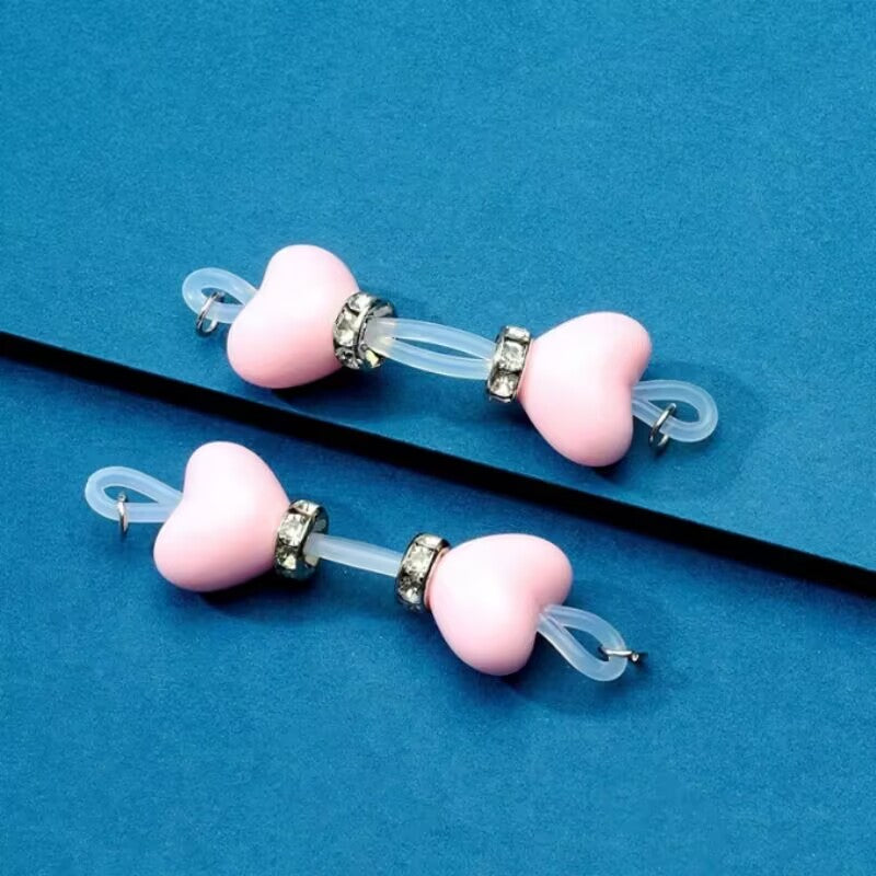 Pair of sweet pastel pink heart soft silicone non-piercing nipple jewelry with clear rhinestone embellishments.