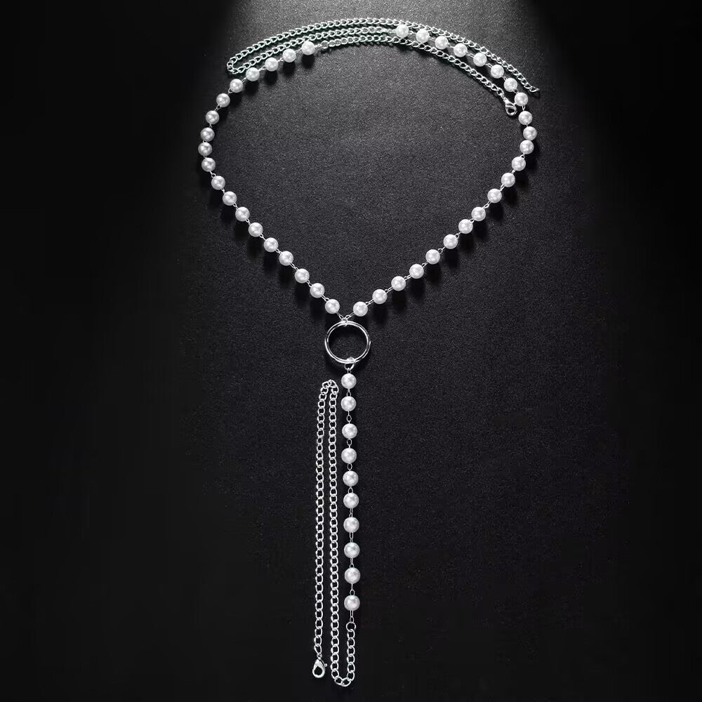 High-lustre pearl thong body harness jewelry displayed on a textured dark background showing total product structure.
