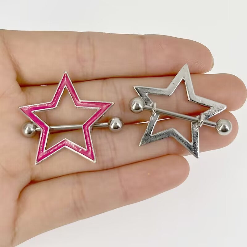 Comparison of pink and silver star nipple shields held in hand for size reference.