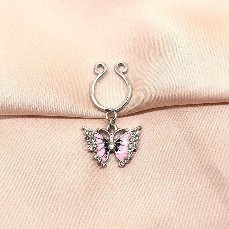 Pink enamel butterfly clip on nipple rings pair displayed on premium silk backdrop