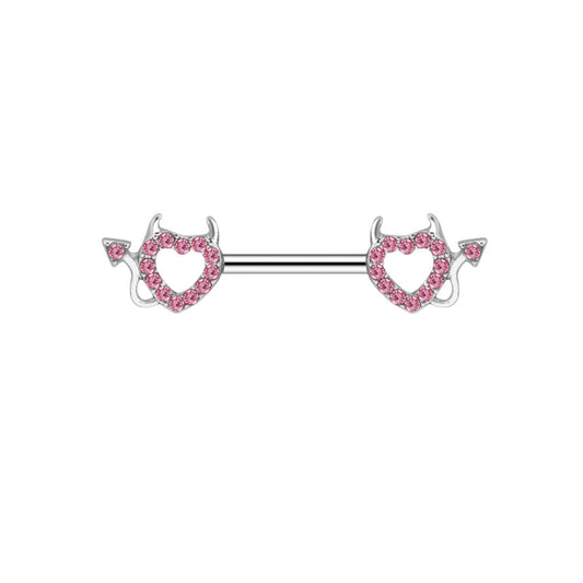 A silver nipple barbell with a pink crystal-encrusted heart charm featuring small devil horns and a tail on a clean white background.