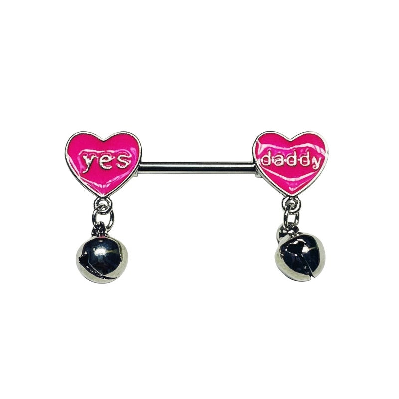 Pink heart nipple barbell featuring "yes" and "daddy" text with hanging mini bell dangles on a white background
