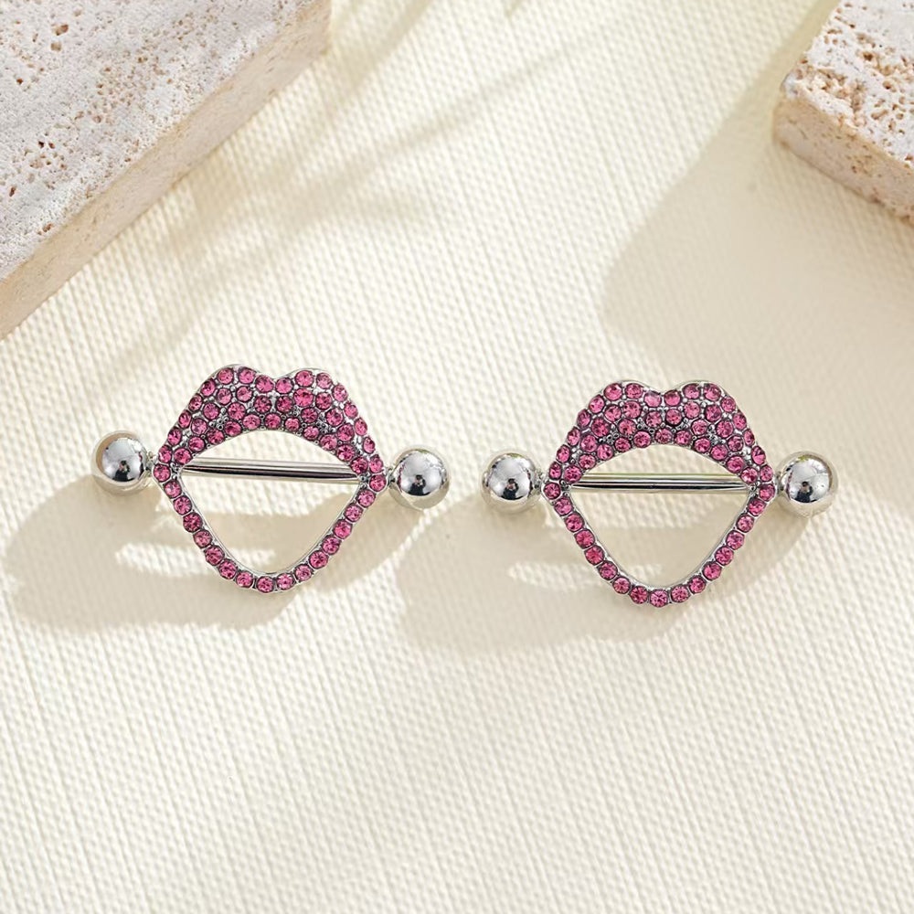 Pair of pink crystal lip nipple shields displayed on aesthetic stone.