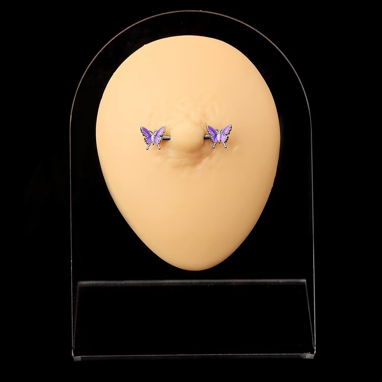 A pair of purple gradient butterfly nipple barbells displayed on a realistic piercing model stand with a black background.