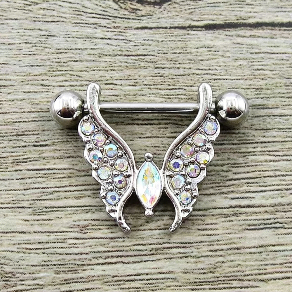 Flat lay real shot of an iridescent AB crystal butterfly wing nipple shield piercing on wood
